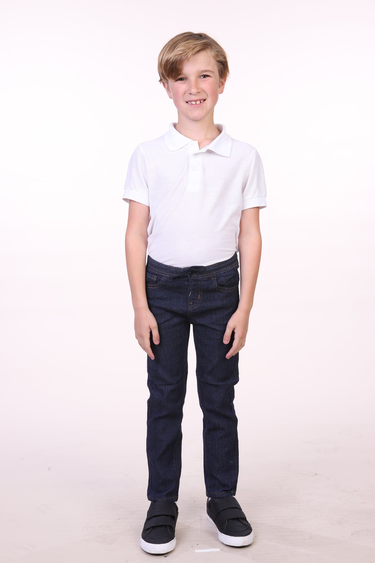 Boy wearing Oscar Kids KA4522 boys' skinny denim jeans in blue indigo, full-length view
