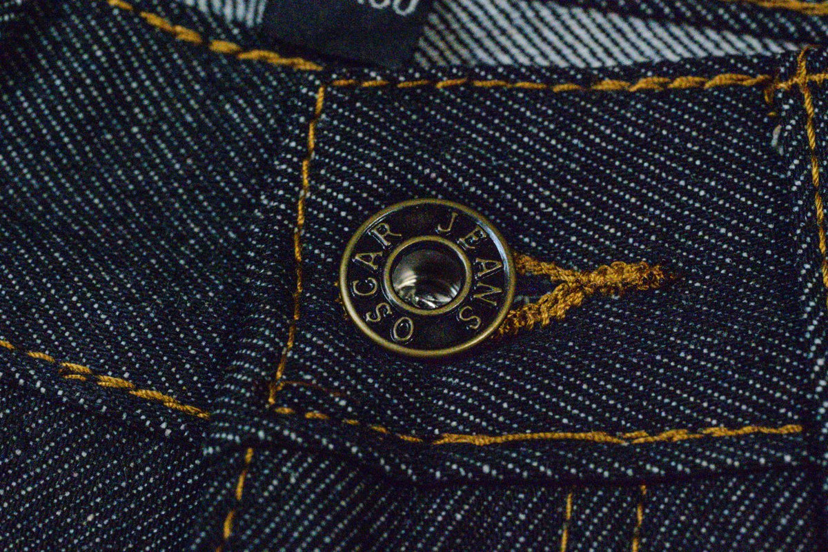 Engraved Oscar Jeans shank button on indigo denim